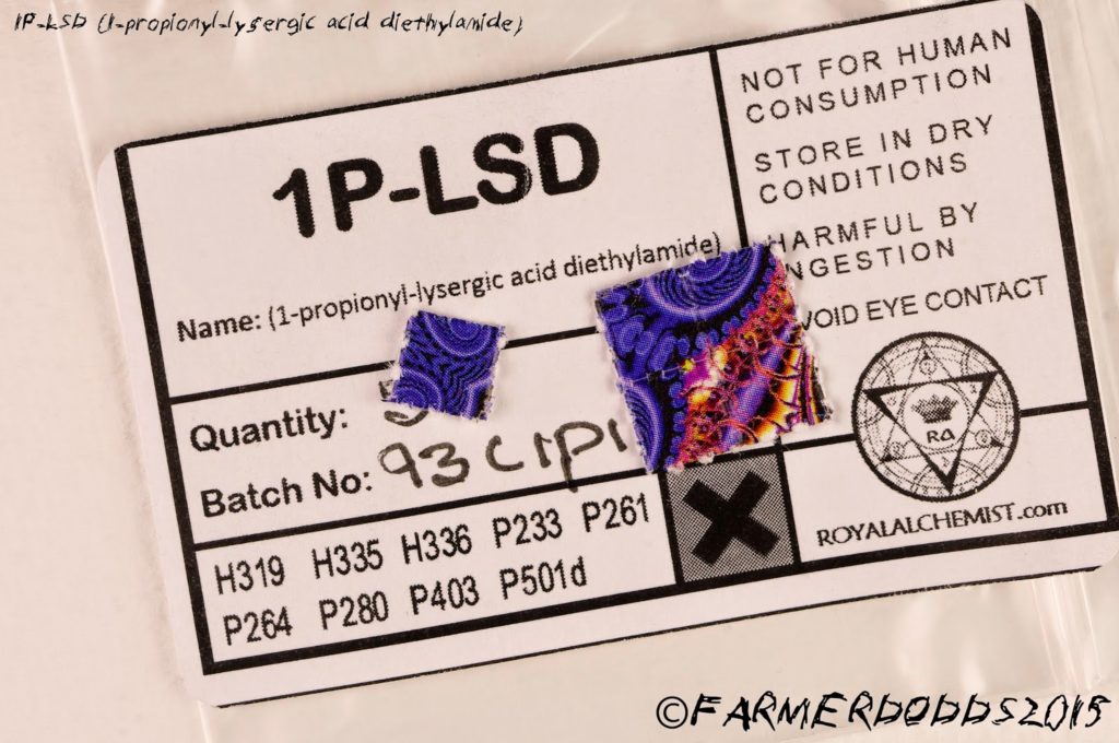 1P-LSD kaufen & günstig im Preisvergleich bestellen – Wirkung, Erfahrungen, Dosierung 13 Zu sehen sind 2 1p-lsd pappen in bunter Farbe auf einem Ausdruck liegend, auf dem die chemischen Eigenschaften dieser Droge zu lesen sind